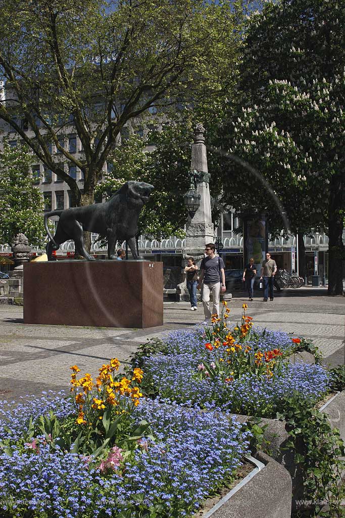 Knigsallee, Koenigsallee, K, Koe, Dsseldorf, Duesseldorf, Niederrhein, Bergisches Land, Blick auf Statue Bergischer Loewe, Lwe in Frhlingsstimmung, Fruehlingsstimmung mit Blumenkbeln, Blumenkuebeln