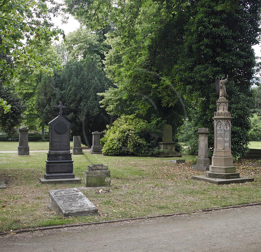 Duesseldorf Golzheim Golzheimer Friedhof, eine der bedeutendsten Gruenanlagen der Stadt Duesseldorf verschiedene Grabmale mit Erbbegraebnis der Familie Wolferts-Mueller mit einem Engel ohne Kopf, rechts im Bild; Duesseldorf-Golzheim, Golzheim cemetery, one of the most important parks, green space of Duesseldorf, several graves with grave of family Wolterts-Mueller with Angel without head on the gravestone, right side