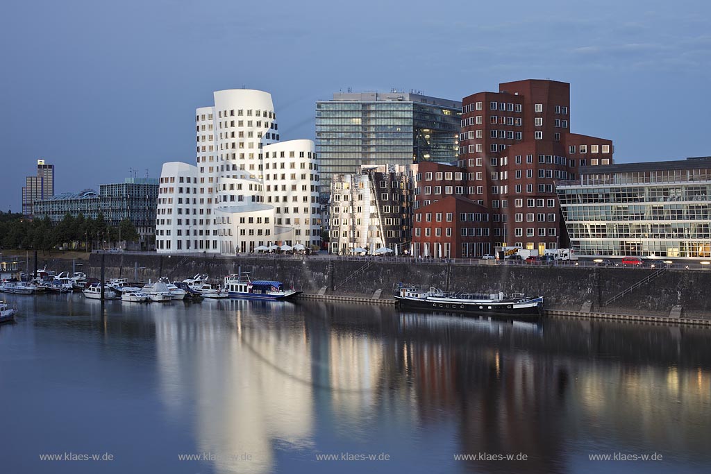 Duesseldorf Hafen, Medienhafen,3 Frank O. Gehry Bauten: Zollhof 3 weisse Fassade, Zollhof 2 Spiegelfassade, Zollhof 1, Backsteinfassade, dahinter das Stadttor, neues Wahrzeichen der Stadt, illuminiert waehrend der blauen Stunde; Duesseldorf-Hafen, 3 Frank O. Gehry buildings: duty yard 3 with white facade, duty yard 2 with mirror facade, duty yard 1 with clinker facade illuminated during blue hour