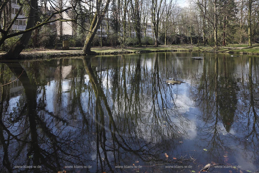 Duesseldorf Pempefort Malkastengarten, Jacobigarten Venusteich im Fruehling mit kahlen Baeumen und Spiegelbild; Duesseldorf Pempelfort Jacobigarden with pond Venusteich in springtime