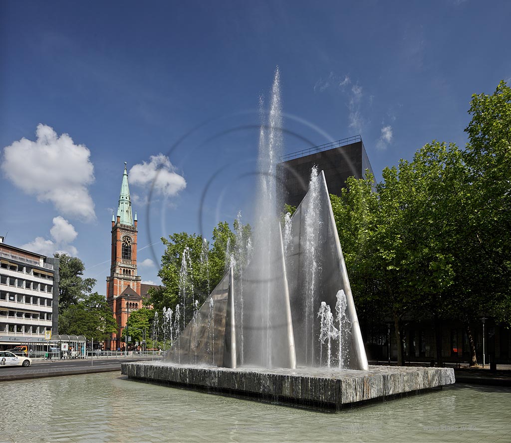 Duesseldorf Stadtmitte, Platz der Deutschen Einheitmit Johanneskirche und  Segelbrunnen, Erbauer: Heinz Mack (1988),Material: Beton - Edelstahl - Naturstein. Die dreieckigen Brunnen-Segel sind 3, 6 und 9 m hoch und von Wasserfontnen umgeben. Der Brunnen wird nach dem Erbauer Mack-Brunnen genannt; Duesseldorf-Stadtmitte, Platz der Deutschen Einheitwith church of Johannes and sailfountain