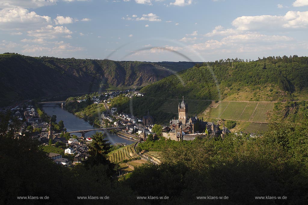 Blick auf Cochem mit Mosel und Reichsburg, die Wahrzeichen von Cochem ist und  auf einem weithin sichtbaren Bergkegel mehr als 100 Meter oberhalb der Stadt steht. Als Gipfelburg gehoert sie zum Typus der Hoehenburgen; view to Cochem with Moselle and Reichsburg.