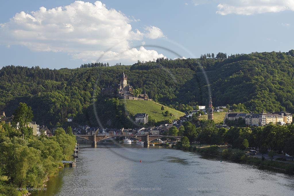 Blick von der Mosel auf Cochem und Reichsburg, die als Wahrzeichen von Cochem gilt und  auf einem weithin sichtbaren Bergkegel mehr als 100 Meter oberhalb der Stadt steht. Als Gipfelburg gehoert sie zum Typus der Hoehenburgen; view to Cochem with Moselle and castle Reichsburg.