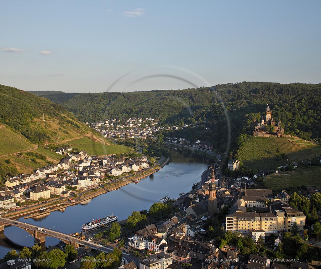 Cochem, Blick ins Moseltal vom Aussichtspunkt Pinner Kreuz auf Mosel, Stadt, Reichsburg und Pfarrkirche Sankt Martin im Abendlicht der untergehenden Sonne; Cochem, view to the valley of Moselle from lookout point cross Pinner Kreuz to Moselle, town, castle Reichsburg and parish church saint Martin  in vespertine sunset.