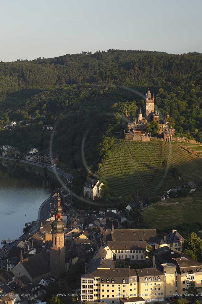 Cochem, Blick ins Moseltal vom Aussichtspunkt Pinner Kreuz auf Mosel, Stadt, Reichsburg und Pfarrkirche Sankt Martin im Abendlicht der untergehenden Sonne; Cochem, view to the valley of Moselle from lookout point cross Pinner Kreuz to Moselle, town, castle Reichsburg and parish church saint Martin  in vespertine sunset.