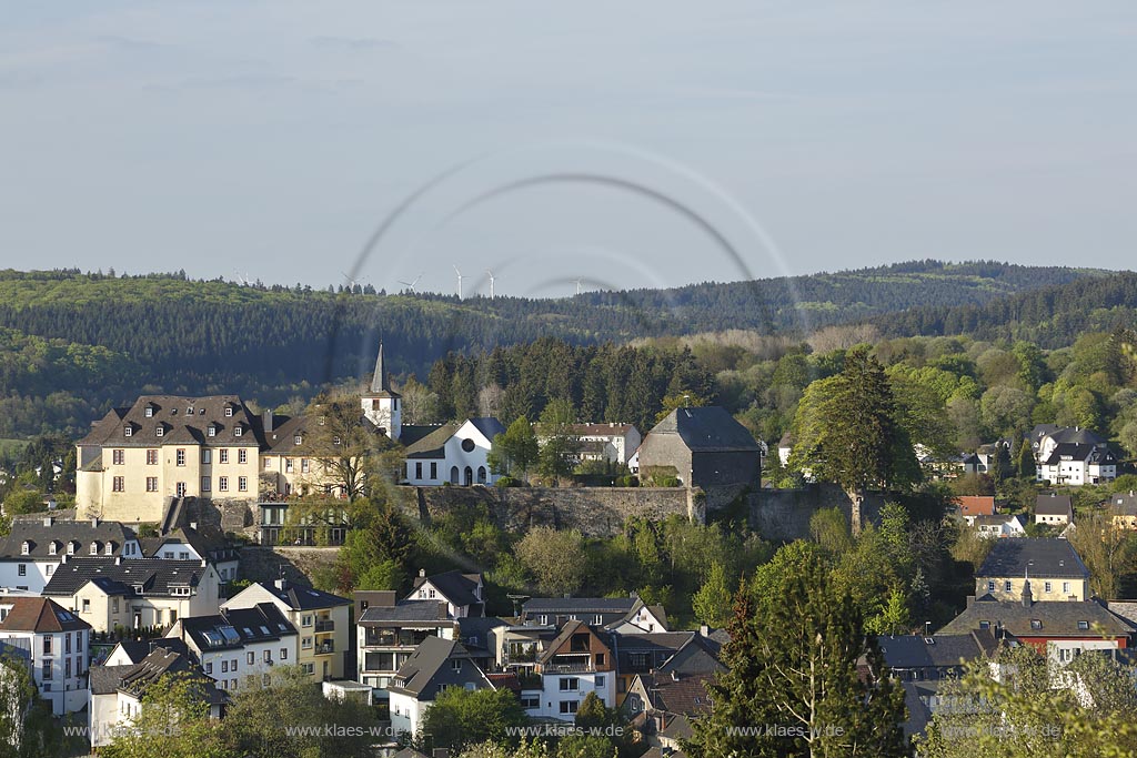 Daun, Stadtpanorama mit Resten der Umfassungsmauern der wohl hochmittelalterlichen, 1689 zerstoerten Burganlage, links im Bild ehemaliges kurtrierisches Amtshaus, rechts dahinter die evangelische neugotische Kirche, rechts Kueppelwalmdachscheune; Daun, panorama of the town with the rest of the enclosure wall of the castle and at the left side the once deanery and behind it  the evangelic church.