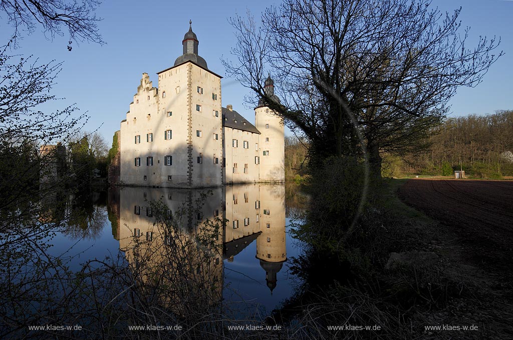 Euskirchen Wisskirchen, die mittelalterliche Burg Burg Veynau ist eine mittelalterliche Wasserburg und die groete Burganlage im Kreis Euskirchen in Nordrhein-Westfalen. Sie zaehlt zu den eindrucksvollsten und bedeutendsten Burgen im Rheinland, Abendaufnahme im waremn Licht der untergehenden Sonne; Euskirchen Wiskierchen moated castle Yeynau in springtime in evening sunlight