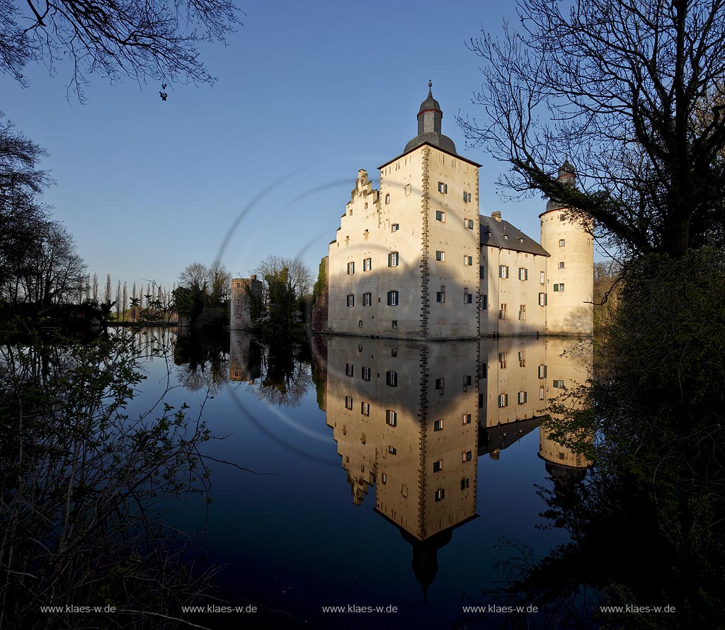 Euskirchen Wisskirchen, die mittelalterliche Burg Burg Veynau ist eine mittelalterliche Wasserburg und die groete Burganlage im Kreis Euskirchen in Nordrhein-Westfalen. Sie zaehlt zu den eindrucksvollsten und bedeutendsten Burgen im Rheinland, Abendaufnahme im waremn Licht der untergehenden Sonne; Euskirchen Wiskierchen moated castle Yeynau in springtime in evening sunlight