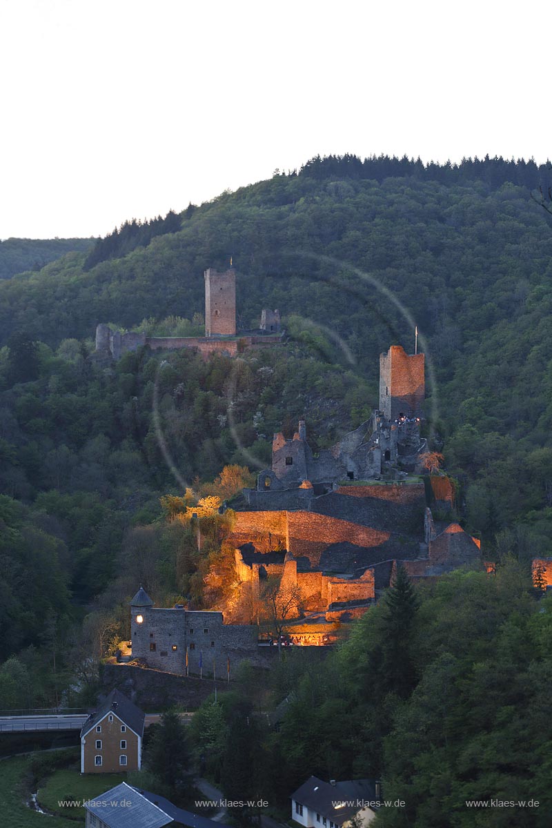 Manderscheid, Blick vom Eifelsteig auf die Ruinen, Burgruine Niederburg vorne rechts und Oberburg hinten links im Bild in Abenstimmung, illuminirt, blaue Stunde; Manderscheid, view onto castle ruines Niederburg, right side in front and Oberburg, left side in rear in the evening during blue hour, illuminated.