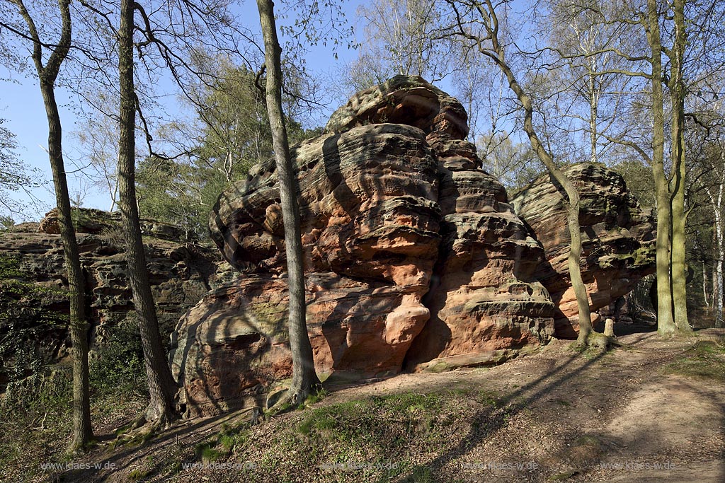 Mechernich die Katzensteine, eine natuerliche Felsformation, Felsen aus Buntsandstein am Rande des Mechernicher Waldes im waremen Licht der tiefstehenden Abendsonne im Fruehling; Euskirchen natural rocks named Katensteine from red sandstone in evening sunlight