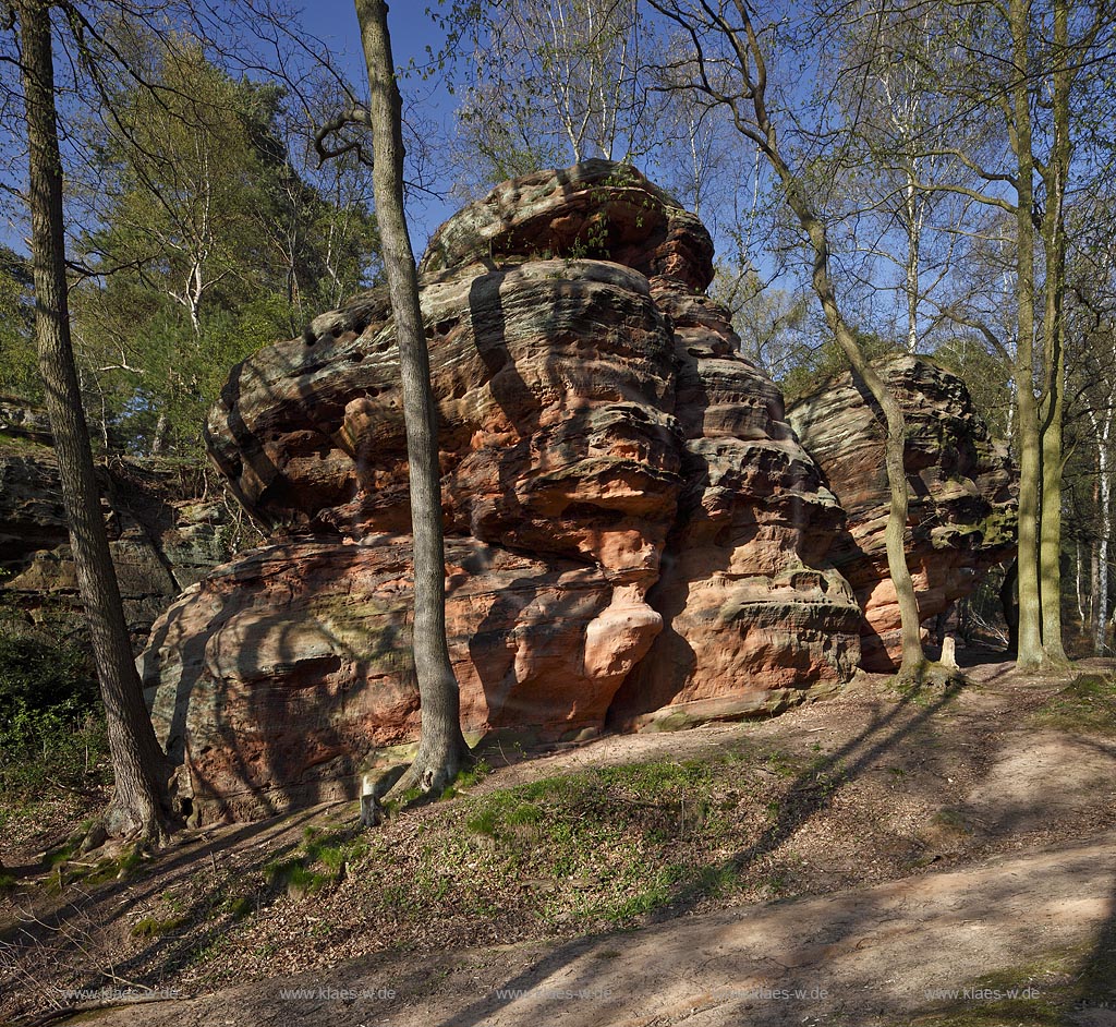 Mechernich die Katzensteine, eine natuerliche Felsformation, Felsen aus Buntsandstein am Rande des Mechernicher Waldes im waremen Licht der tiefstehenden Abendsonne im Fruehling; Euskirchen natural rocks named Katensteine from red sandstone in evening sunlight