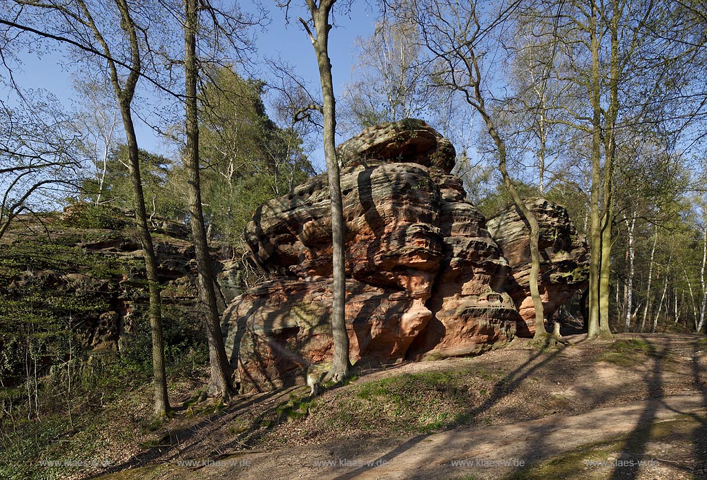 Mechernich die Katzensteine, eine natuerliche Felsformation, Felsen aus Buntsandstein am Rande des Mechernicher Waldes im waremen Licht der tiefstehenden Abendsonne im Fruehling; Euskirchen natural rocks named Katensteine from red sandstone in evening sunlight