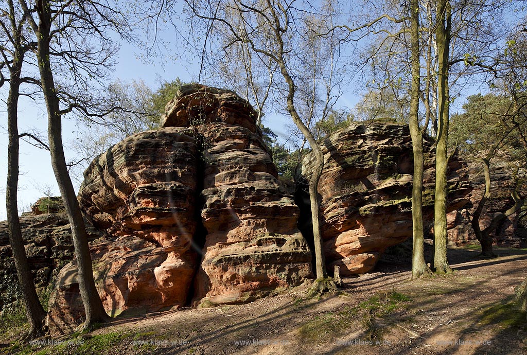 Mechernich die Katzensteine, eine natuerliche Felsformation, Felsen aus Buntsandstein am Rande des Mechernicher Waldes im waremen Licht der tiefstehenden Abendsonne im Fruehling; Euskirchen natural rocks named Katensteine from red sandstone in evening sunlight