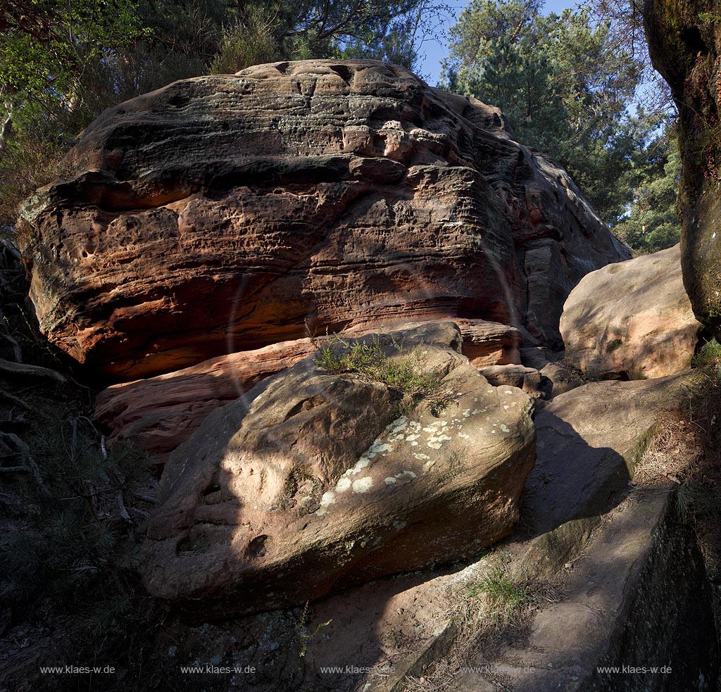 Mechernich die Katzensteine, eine natuerliche Felsformation, Felsen aus Buntsandstein am Rande des Mechernicher Waldes im waremen Licht der tiefstehenden Abendsonne im Fruehling; Euskirchen natural rocks named Katensteine from red sandstone in evening sunlight