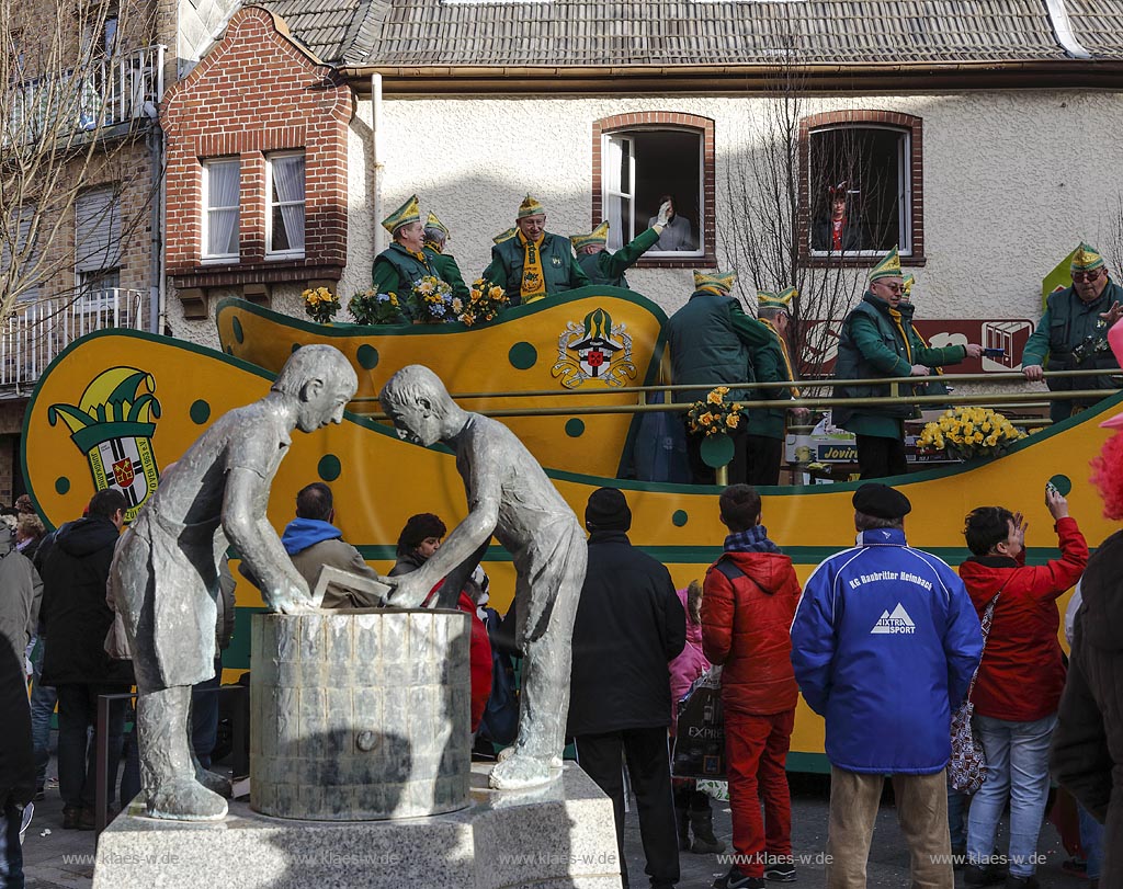 Zuelpich, Papiermacherbrunnen, im Hintergrund Rosenmontagszug Hovener Jungkarnevalisten; Zuelpich fountain "Papiermacherbrunnen" at carnival