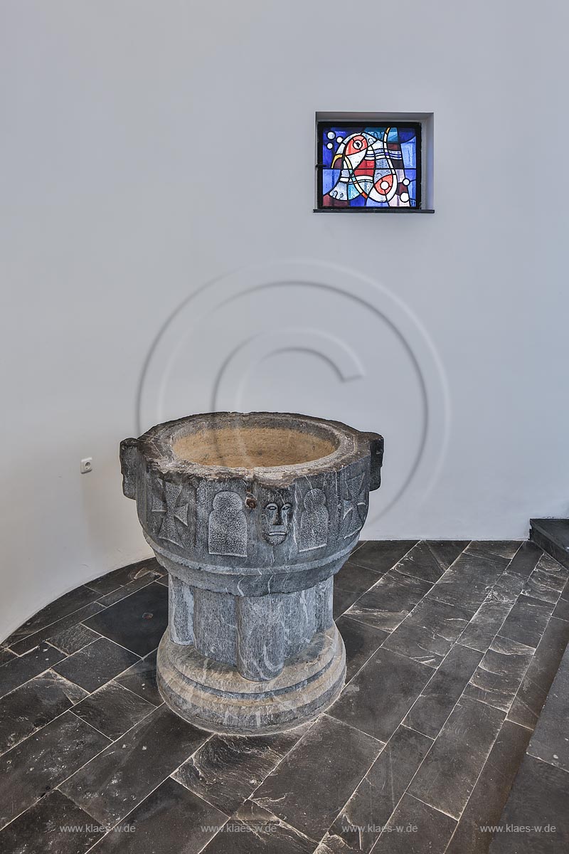 Zuelpich St. Peter Kirche Taufkapelle mit dem Taufstein aus Namurer Blaustein,12. Jahrhundert, Unterbau 1978 erneuert, Buntglasscheibe mit Fischsymbol von1955; Zuelpich church St. Peter interior view, baptistry with baptistmal font, 12th century, stained-glass window with fish symbol, 1955.