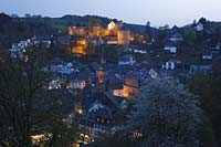 Monschau, Blick auf die Altstadt mit Burg Monschau und Rotes Haus in der Abenddämmerung, blaue Stunde, illuminiert; View to old town of Monschau with castle and red house in evening light, nightlite image, illumination