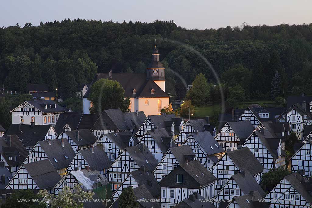 Freudenberg Fotoblick Alter Flecken, Blick auf die Altstadt mit den historischen Fachwerkhauesern in Abenstimmung zur blauen Stunde mit illuminierter Pfarrkirche, evangelische Kirche,  der Alte Flecken ist die ganz in Fachwerkbauweise errichtete Innenstadt Freudenbergs. Sie gibt einen Eindruck von einer Kleinstadt aus dem 17. Jahrhundert. Der Alte Flecken wurde in den Kulturatlas des Landes Nordrhein-Westfalen als von internationaler Bedeutung aufgenommen; View to romantic historical oldtown of Freudenberg with a lot of framework houses and the evangelic church with illumination in evening light