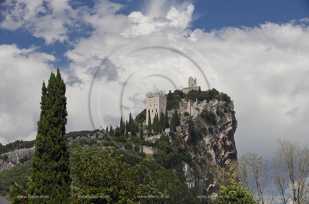 Arco blick zur Burg Arco mit ihren zinnenbekroenten Tuermen zwischen Zypressen mit Wolkenstimmung; Castle Arco the ambattled towers among the cypress trees; Castello Arco le torri merlate tra i cipressi 