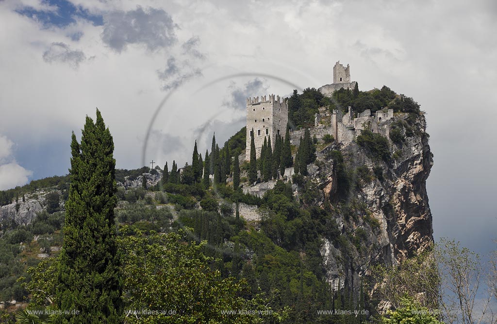 Arco blick zur Burg Arco mit ihren zinnenbekroenten Tuermen zwischen Zypressen mit Wolkenstimmung; Castle Arco the ambattled towers among the cypress trees; Castello Arco le torri merlate tra i cipressi 