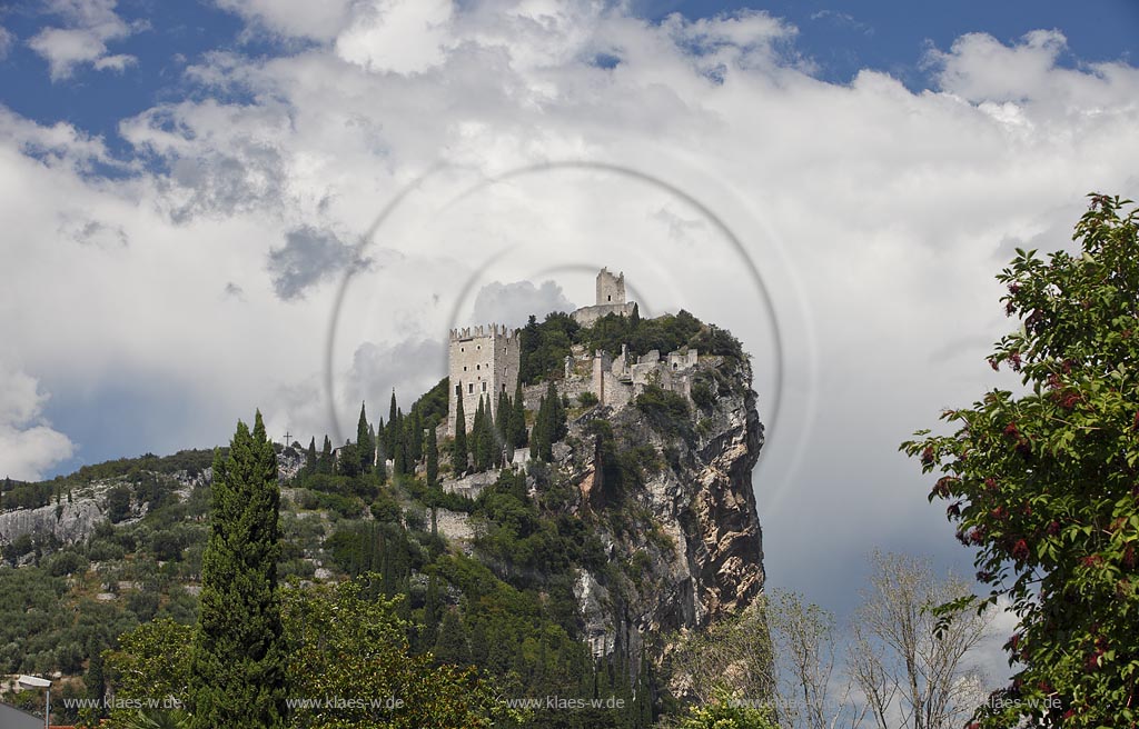 Arco blick zur Burg Arco mit ihren zinnenbekroenten Tuermen zwischen Zypressen mit Wolkenstimmung; Castle Arco the ambattled towers among the cypress trees; Castello Arco le torri merlate tra i cipressi 