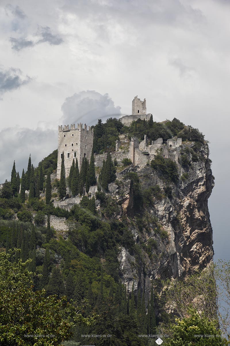 Arco blick zur Burg Arco mit ihren zinnenbekroenten Tuermen zwischen Zypressen mit Wolkenstimmung; Castle Arco the ambattled towers among the cypress trees; Castello Arco le torri merlate tra i cipressi 