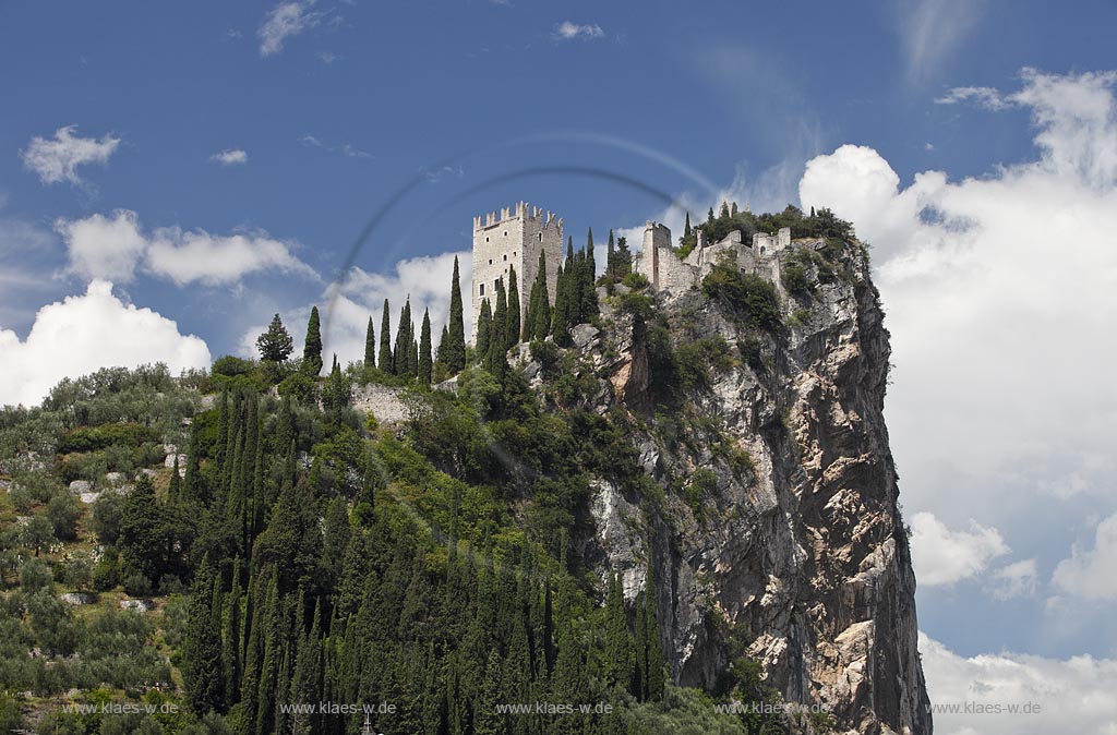 Arco blick zur Burg Arco mit ihren zinnenbekroenten Tuermen zwischen Zypressen mit Wolkenstimmung; Castle Arco the ambattled towers among the cypress trees; Castello Arco le torri merlate tra i cipressi 