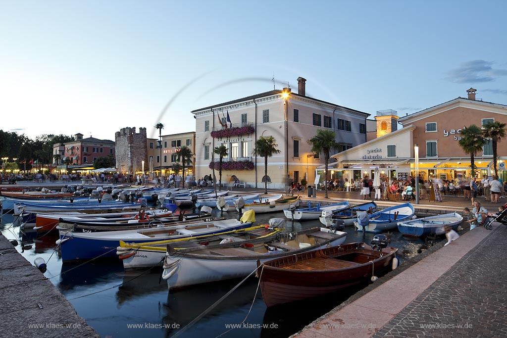 Bardoline am Gardasee, Blick ueber den Hafen mit Fischerbooten und dem mittelalterlichen Turm in Abendstimmung zur blauen Stunde; Bardolino at Lake Garda view over port with fishin boats and the mediaeval tower during blue hour; Bardolino centro storice, il portificciale, allietato da barche multicolori, torre medioevale la vita notturna inizia