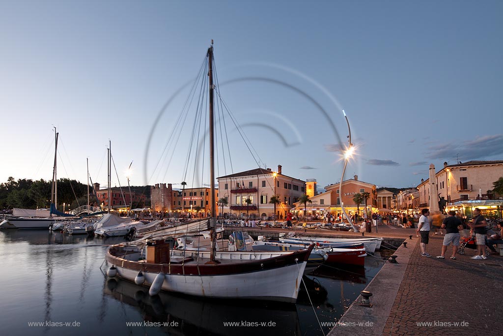 Bardoline am Gardasee, Blick ueber den Hafen mit Fischerbooten und dem mittelalterlichen Turm in Abendstimmung zur blauen Stunde; Bardolino at Lake Garda view over port with fishin boats and the mediaeval tower during blue hour; Bardolino centro storice, il portificciale, allietato da barche multicolori, torre medioevale la vita notturna inizia