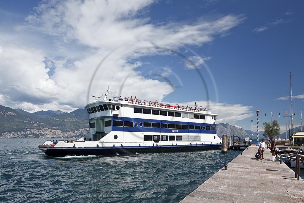Castelletto Di Brenzone, Blick von der Hafenmole auf den Gardasse mit dem Faehrschiff Brescia mit 688 Plaetzen der Schiffahrtsgesellschaft Navigarda gegen das Bergmassiv des Westufers des Gardasees;  Castelletto Di Brenzone, view fom mole over lake Garda with passanger ferry, ferry ship Brescoa, against the rock mass of West Garda Riviera