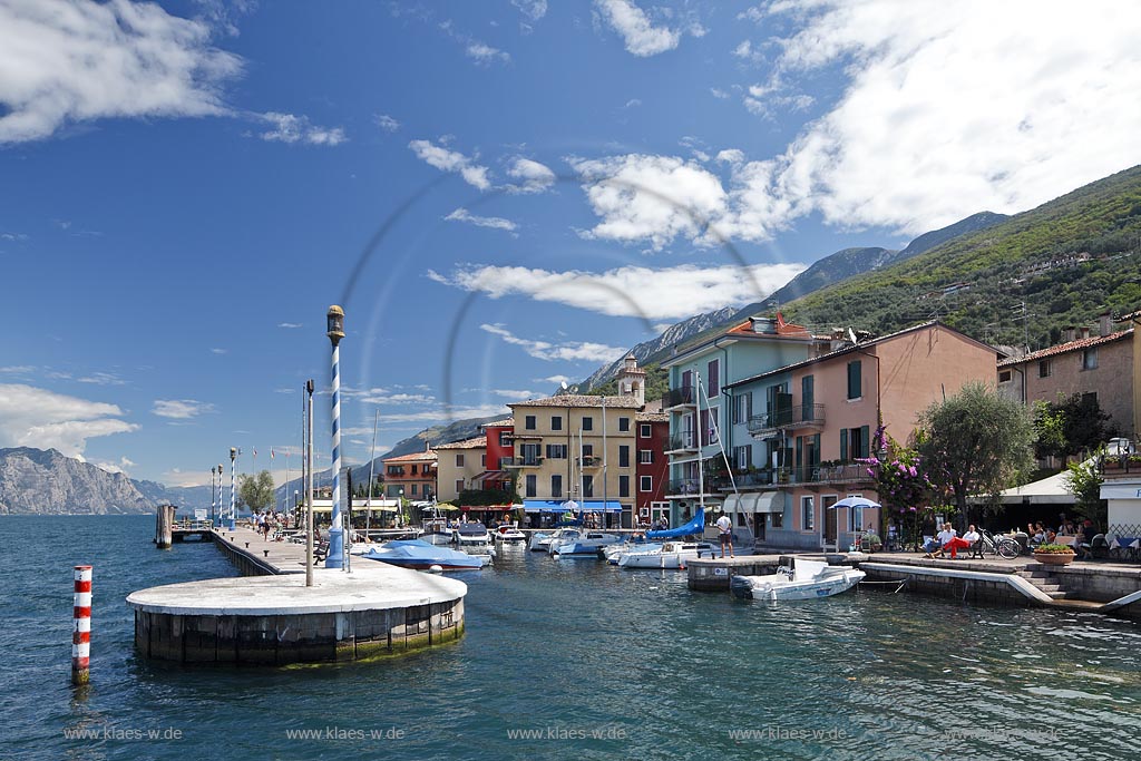 Castelletto Di Brenzone, Blick auf Hafenmole und Hafen mit Fischerbooten und bunten Haeusern gegen Monte Baldo; Castelletto Di Brenzone, view to the mole and port with fishing boats to old prettily pointed houses, in the Background Monte Baldo mountain