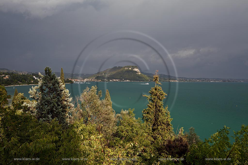 Garda Blick auf die Bucht von Garda mit dem Roccca di Garda in Gewitterstimmung mit dunklen Wolken und Sonnenschein; Garda view to the bay of Garda with mountain Rocca di Garda in thunder storm atmosphere with dark cluds and sunshine
