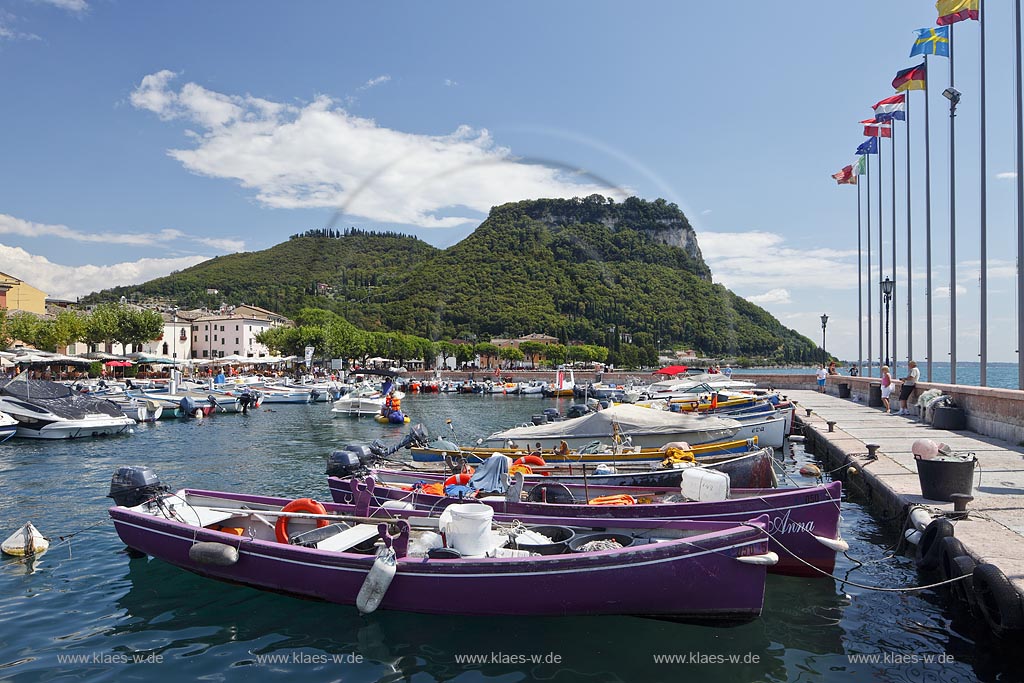 Garda Blick von der Hafenmole ueber Hafen mit bunten Fischerbooten,  Palazzo dei Capitani und Rocca di Garda im Hintergrund; Garda view from mole over port with colourful fishing boats, Palazzo dei Capitani and mountain Rocca di Garda in backgound