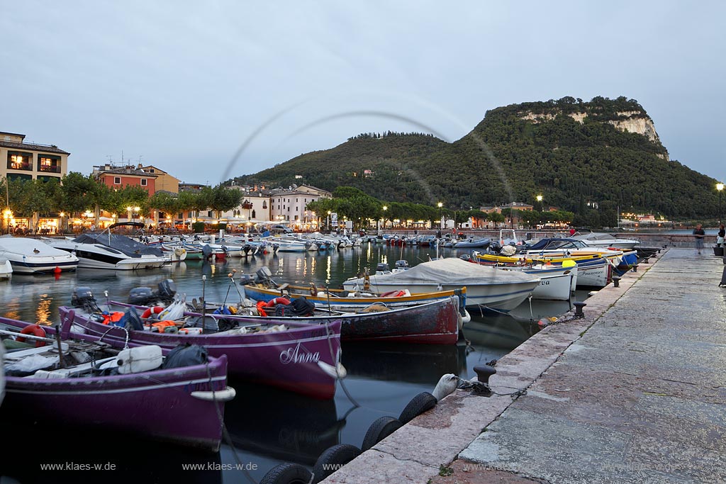 Garda Blick von der Hafenmole ueber Hafen mit bunten Fischerbooten,  Palazzo dei Capitani und Rocca di Garda im Hintergrund; Garda view from mole over port with colourful fishing boats, Palazzo dei Capitani and mountain Rocca di Garda in backgound