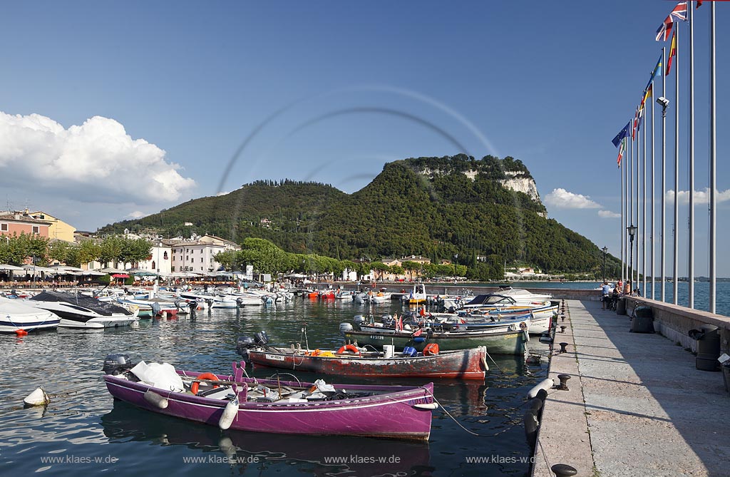 Garda Blick von der Hafenmole ueber Hafen mit bunten Fischerbooten,  Palazzo dei Capitani und Rocca di Garda im Hintergrund; Garda view from mole over port with colourful fishing boats, Palazzo dei Capitani and mountain Rocca di Garda in backgound