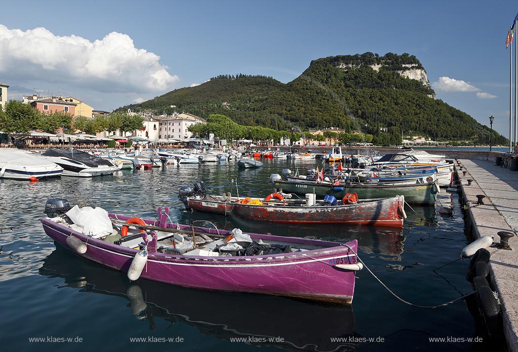 Garda Blick von der Hafenmole ueber Hafen mit bunten Fischerbooten,  Palazzo dei Capitani und Rocca di Garda im Hintergrund; Garda view from mole over port with colourful fishing boats, Palazzo dei Capitani and mountain Rocca di Garda in backgound