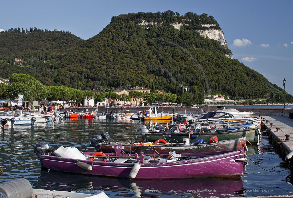 Garda Blick von der Hafenmole ueber Hafen mit bunten Fischerbooten,  Palazzo dei Capitani und Rocca di Garda im Hintergrund; Garda view from mole over port with colourful fishing boats, Palazzo dei Capitani and mountain Rocca di Garda in backgound