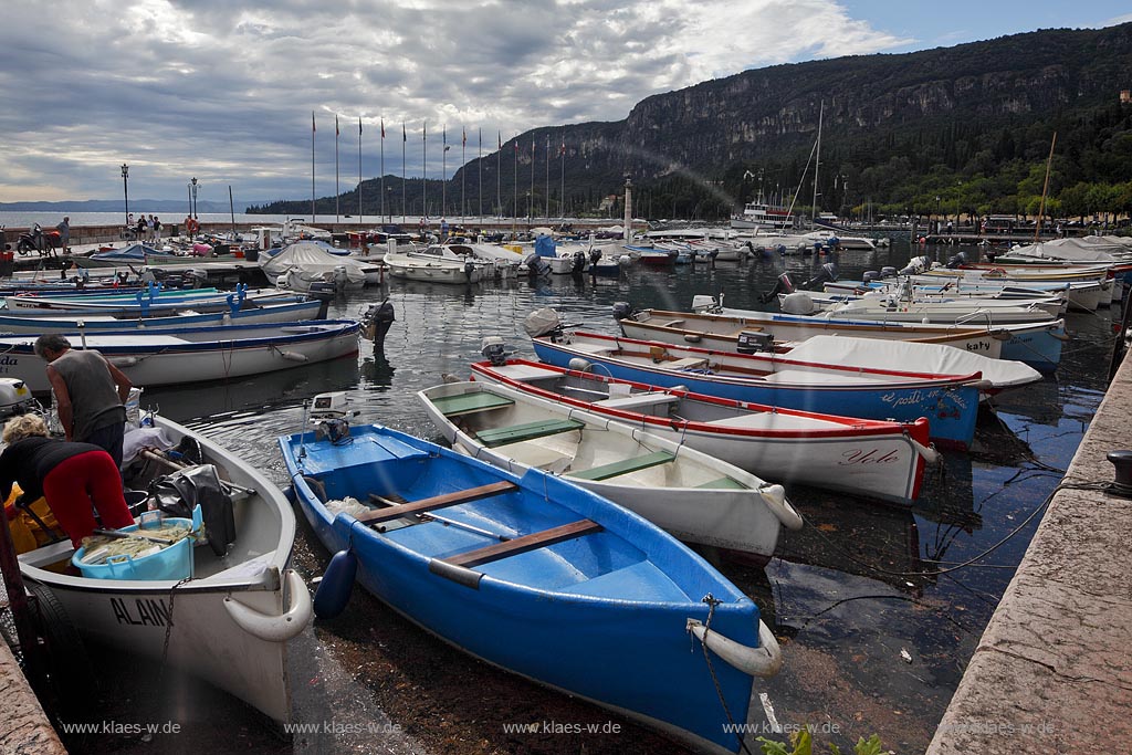 Garda Blick ueber Hafen mit bunten Fischerbooten und Hafenmole in Wolkenstimmung; Garda view over port with colourful fishing boats and mole in atmosheric light with clouds