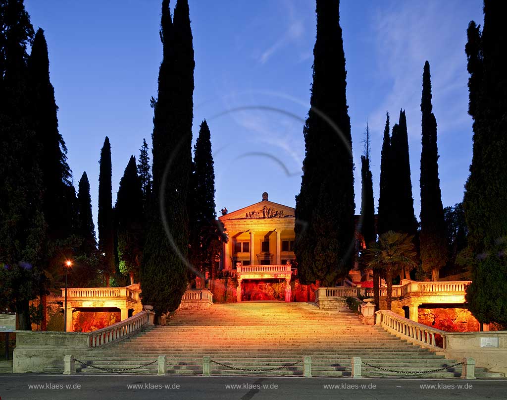 Gardone Riviera, die Frontseite mit Treppenaufgang der Villa Alba zur blauen Stunde, illuminiert, Treppe von Zypressen umgeben; Gardone Riviera, Villa Alba mainfront with stais and Meditarrain cypress during blue hour.