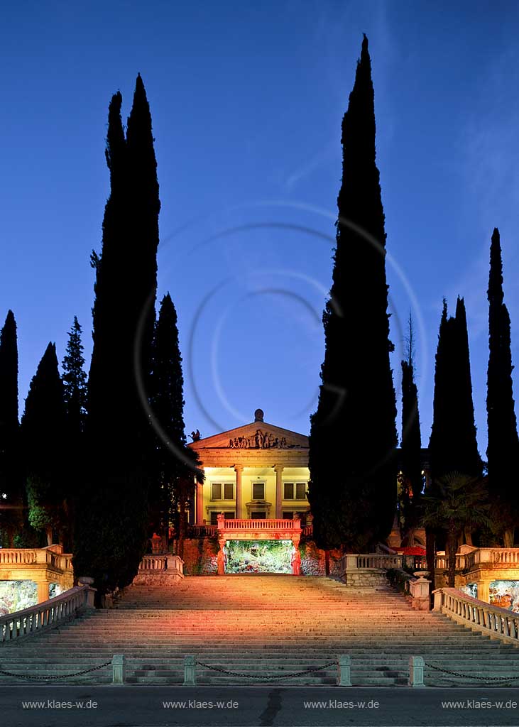 Gardone Riviera, die Frontseite mit Treppenaufgang der Villa Alba zur blauen Stunde, illuminiert, Treppe von Zypressen umgeben; Gardone Riviera, Villa Alba mainfront with stais and Meditarrain cypress during blue hour.