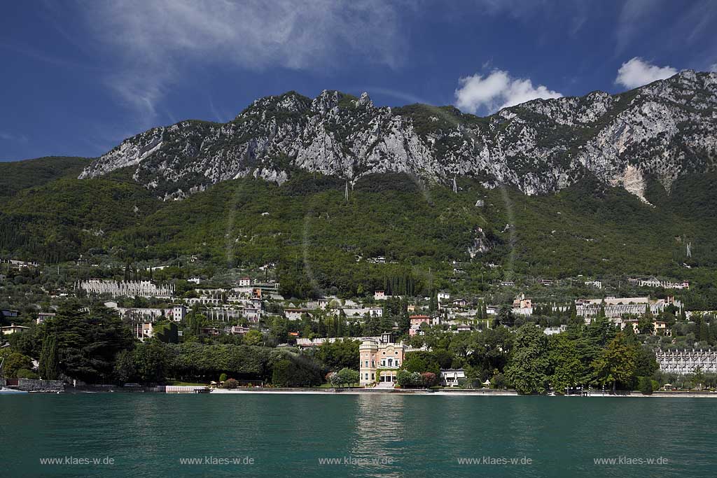 Gargnano, Blick vom See auf Villa Feltrinell mit dem Monte Denervo. In der Villa, die ehemals der Familie des Papierfabrikanten Feltrinelli gehoerte und in der waehrend der faschistischen Republik von Salo von 1943 bis 1945 Benito Mussolini wohnte, ist heute das Grand Hotel a Villa Feltrinelli untergebracht. Der amerikanische Hotelier und Millionaer Robert H. Burns kaufte die Villa 1997, investierte etwa 30 Millionen Euro und bewahrte sie so vor dem Verfall; Gargnao, historical Villa Felirini  is today the Grand Hotel a Villa Fetrini, view from lake with Monte Deverno in the background.
