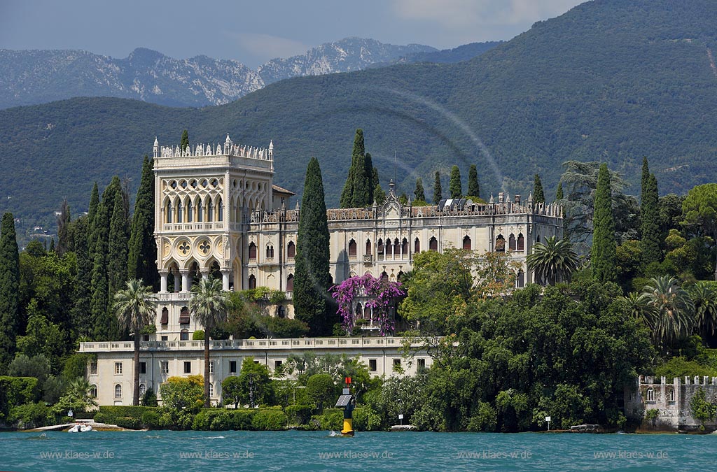 Isola del Garda Blcik vom Gardasee aus zur Insel mit der im venezianisch neugotischen Stil erbauten Villa gegen Monte San Batolomeo; Isola del garda, view from the Lake Garda to the villa built in venetian neo-Gothic stile, against mountain Monte St. Batolomeo; Isola del Garda, Lago di Garda  un palazzo neo gotico in stile veneziano et Monte San Batolomeo