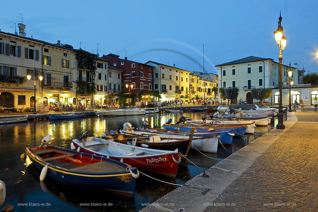 Lazise, Blick uber den Hafen mit bunten Fischerbooten und Haeusern zur blauen Stunde; Lazise, view over the port with colourfull fishing boats and houses during blue hour