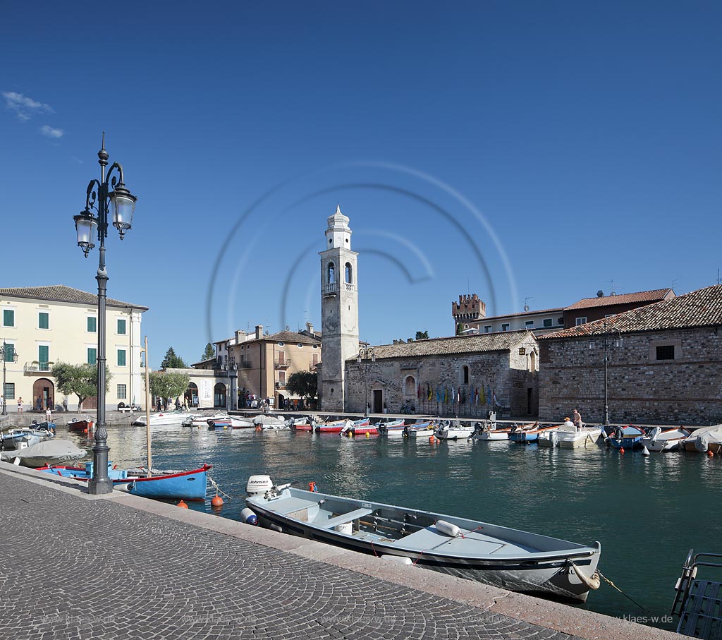 Lazise Blick ueber den Hafen mit Fischerbooten zur kleinen Kirche St. Nicolo bei wolkenlosem Himmel; Laszise view over the port with fishing boats to the church of San Nicolo with cloudless sky; Lazise il portoicciolo, la chiesa romanica di San Nicolo 