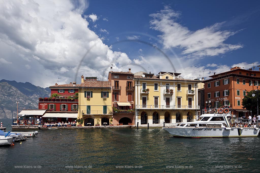 Malcesina, Blick ueber den Hafen mit Motoryacht und bunten Haeusern in extremer Wolkenstimmung; Malcesine view over port with motoryacht and pettily painted houses, atmospheric clouds