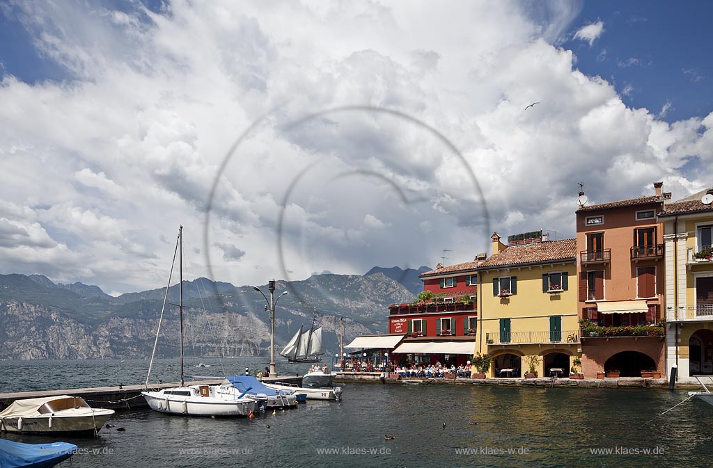 Malcesina, Blick ueber den Hafen mit Motorbooten und bunten Haeusern in extremer Wolkenstimmung, Faehrschiff Tonale auf dem gardasee; Malcesine view over port with motorsboat, motoryacht and pettily painted houses, atmospheric clouds, ferryboat Tonale on lake garda