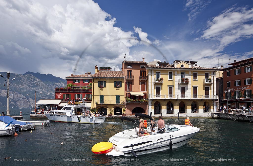 Malcesina, Blick ueber den Hafen mit Motorboot, Motoryacht und bunten Haeusern in extremer Wolkenstimmung; Malcesine view over port with motorsboat, motoryacht and pettily painted houses, atmospheric clouds