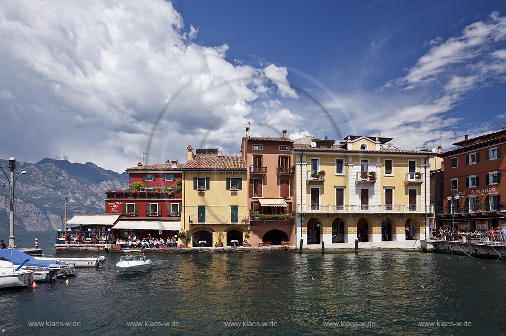 Malcesina, Blick ueber den Hafen mit Motorbooten und bunten Haeusern in extremer Wolkenstimmung, Faehrschiff Tonale auf dem gardasee; Malcesine view over port with motorsboat, motoryacht and pettily painted houses, atmospheric clouds, ferryboat Tonale on lake garda