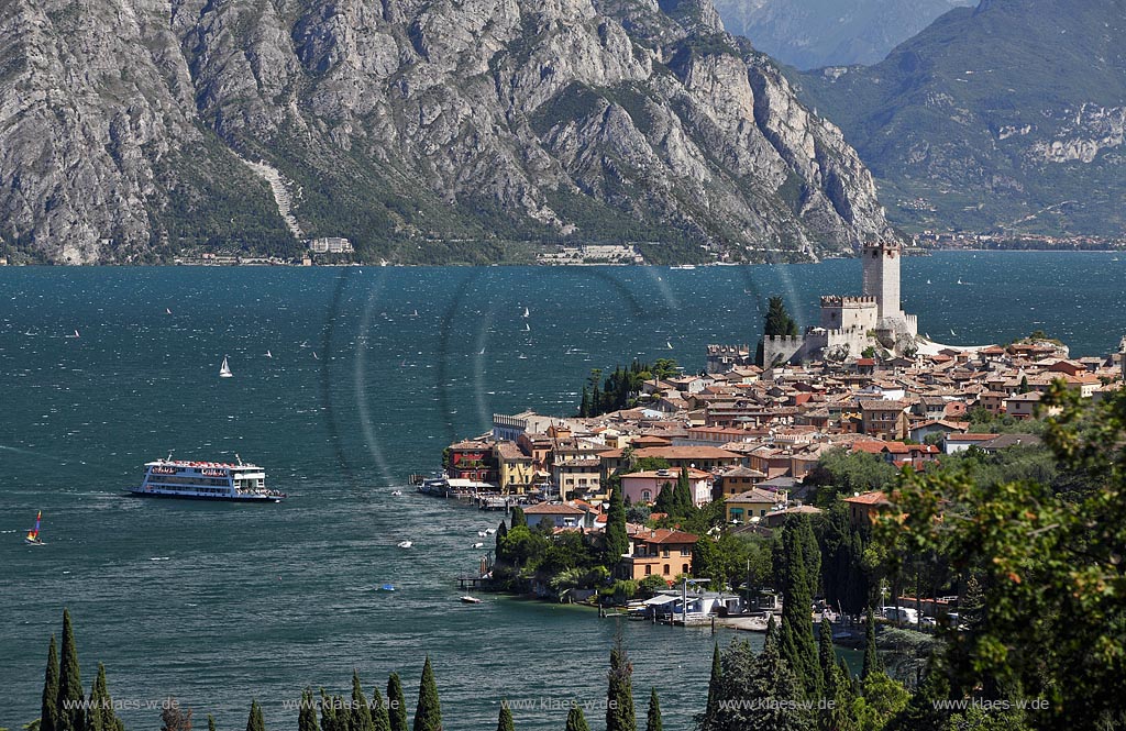 Malcesine, Blick auf den Ort mit Scaligerburg, Hafen, Gardasee und Faehrschiff Berennero vor Bergmassiv; Malcesine, view to town with Scaliger castle, port, Lake garda with ferryboat Brennero 