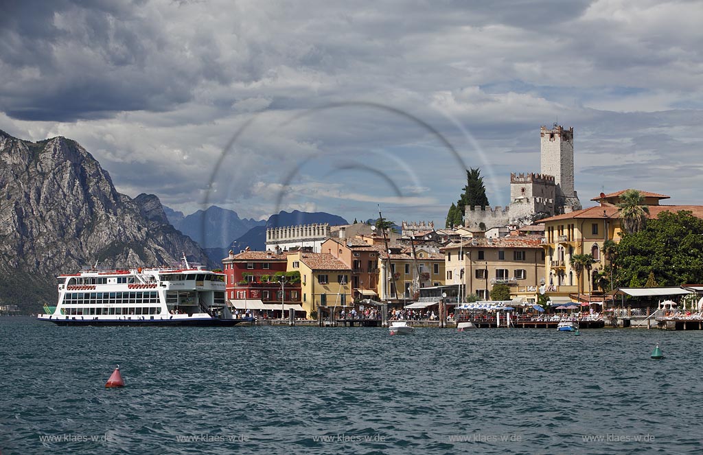 Malcesine, Panoramablick vom Gardasee auf den Ort mit Scaligerburg, Hafen und Faehrschiff Tonale der Schifffahrtsgesellschaft Navigarda, Seeseite; Malcesine, panorama view from Lake Garda to the seafront of Malcesine with Scaliger castle, port and ferryboat Tonale